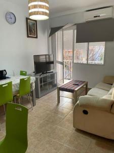 a living room with a couch and a table and a tv at At Moustapha in San Juan de Aznalfarache