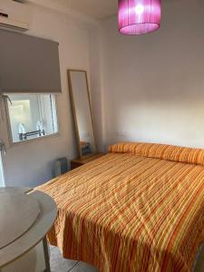 a bedroom with a bed and a pink lamp at At Moustapha in San Juan de Aznalfarache