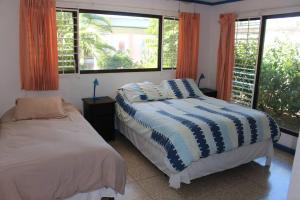 a bedroom with a bed and two windows at Casa de Playa in Chacarita