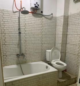 a bathroom with a bath tub and a toilet at Cahaya Residence The Guest House in Kuta