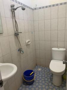 a bathroom with a shower and a toilet and a sink at Cahaya Residence The Guest House in Kuta