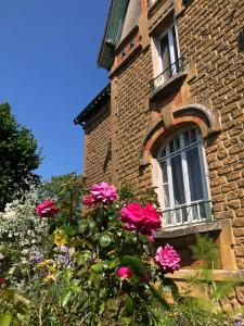 een bos roze bloemen voor een gebouw bij Villa bonne entente in Donchery