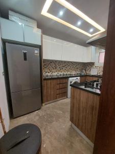 a kitchen with a stainless steel refrigerator and a stove at صن سيتي in Cairo