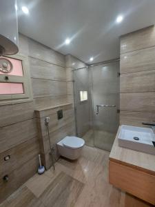 uma casa de banho com um WC, um chuveiro e um lavatório. em صن سيتي em Cairo
