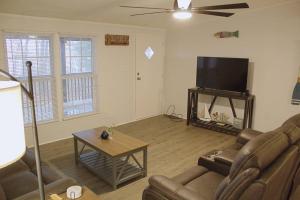 uma sala de estar com um sofá e uma televisão de ecrã plano em Lakeside Retreat em Quitman