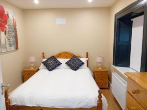 1 dormitorio con 1 cama con 2 mesitas de noche y 2 lámparas en Fenniscourt Cottage en Carlow