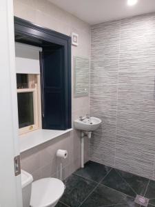 La salle de bains est pourvue d'un lavabo et de toilettes. dans l'établissement Fenniscourt Cottage, à Carlow