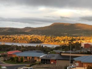 a view of a town with a lake and a mountain at Sunshine Apartment in Austins Ferry +7 photos