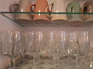 una fila de copas de vino sentadas en un estante en Pombal Suite, en Pombal