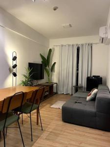 - un salon avec un canapé et une table avec des chaises dans l'établissement Apartamento Piauhy - Studio, à Teresina