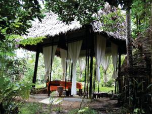 ośrodek wypoczynkowy z łóżkiem i dachem krytym strzechą w obiekcie Amazona Lodge w mieście Leticia