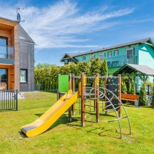 a playground with a slide in a yard at Apartament w Nautikka Resort Krynica Morska in Krynica Morska