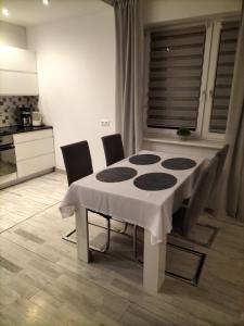 a dining room table with chairs and a white table cloth at Apartament Ustroń Jaszowiec in Ustroń