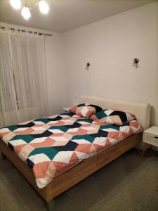 ein Schlafzimmer mit einem Bett mit einer bunten Bettdecke in der Unterkunft Apartament Ustroń Jaszowiec in Ustroń