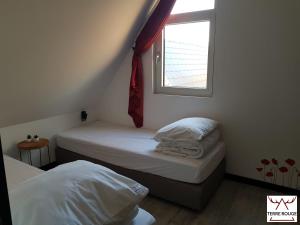 2 Betten in einem kleinen Zimmer mit Fenster in der Unterkunft Terre Rouge - Terra Rubica - Les Terrasses de Malmedy in Malmedy
