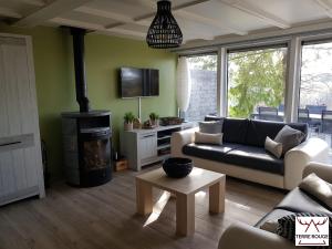 uma sala de estar com um sofá e um fogão em Terre Rouge - Terra Rubica - Les Terrasses de Malmedy em Malmedy