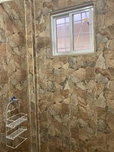 a bathroom with a stone wall and a window at Chango's Apartments in Bocas del Toro
