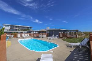 a patio with a swimming pool and chairs at Clipper - Oceanfront Outer Banks Home with Private Pool - 5BR/3.5BA in Southern Shores