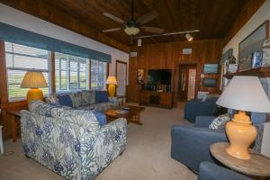 a living room with blue furniture and a ceiling fan at Clipper - Oceanfront Outer Banks Home with Private Pool - 5BR/3.5BA in Southern Shores