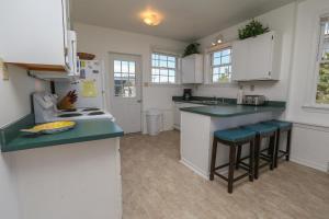 a kitchen with white cabinets and green counter tops at Clipper - Oceanfront Outer Banks Home with Private Pool - 5BR/3.5BA in Southern Shores