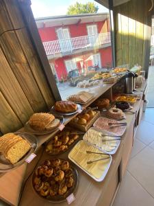 una línea de buffet con muchos tipos diferentes de repostería en Pousada VHL - Campos do Jordão, en Campos do Jordão