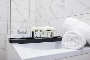 y baño con lavabo y bañera con toallas. en Brand New Modern Block of Apartments By AV Stays Short Lets London en Croydon