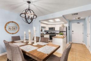 a kitchen and dining room with a wooden table and chairs at Beach Villas # 305 - Recently Refereshed! condo in Fort Myers Beach