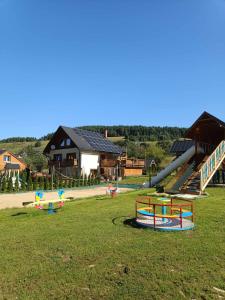 a playground with slides and play equipment in a field at Gościnna Chata in Jaworki