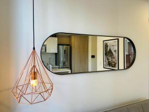 un espejo colgado en una pared con una lámpara en Capital By Wynwood House, en Bogotá