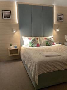 a bedroom with a large bed with a headboard at WiLLA APART in Władysławowo