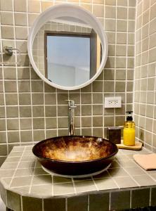 a bathroom with a copper sink and a mirror at Seagull Cove Resort in Boca Chica