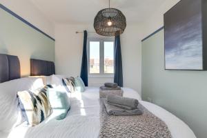 sypialnia z dużym białym łóżkiem z poduszkami w obiekcie Cosy 2 bedroom house - With Free Parking and Wifi w mieście Chelmsford