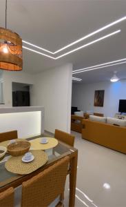 une salle à manger avec une table, des chaises et un canapé dans l'établissement Casa linda em Unamar!, à Cabo Frio