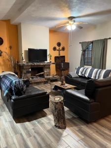 a living room with black leather furniture and a piano at Finca Campestre Los Pinos in Arteaga