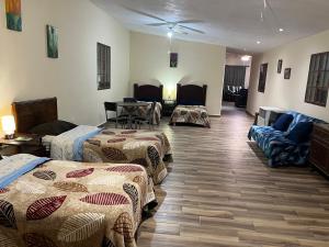 um quarto de hotel com três camas e um sofá em Finca Campestre Los Pinos em Arteaga