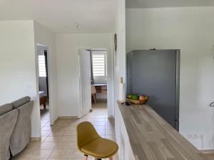 uma sala de estar com um sofá e um frigorífico em Logement Charme vanillé - Gosier - 2 chambres - Piscine - Wifi - Parking em Le Gosier