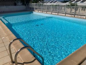 una piscina con acqua blu in un edificio di Logement Charme vanillé - Gosier - 2 chambres - Piscine - Wifi - Parking a Le Gosier