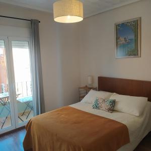 バレンシアにあるLuminoso Apartamento * La Marina de Valenciaのベッドルーム(ベッド1台付)、バルコニーが備わります。