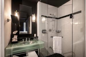a bathroom with a sink and a shower at Hôtel Le Germain Québec in Quebec City +30 photos