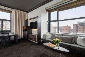 a living room with a couch and a large window at Hôtel Le Germain Québec in Quebec City
