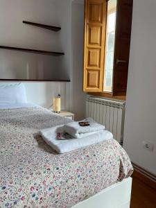 een slaapkamer met een bed met twee handdoeken erop bij Apartamento Sarmiento- Casco histórico Mondoñedo in Mondoñedo