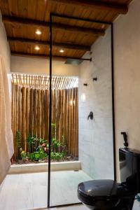łazienka z prysznicem, toaletą i oknem w obiekcie Suite DAVI - Guest House Guaiu w mieście Santa Cruz Cabrália