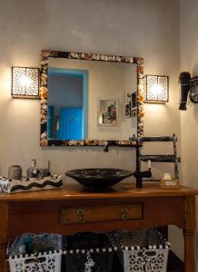 a bathroom with a sink and a mirror on a table at Suite DAVI - Guest House Guaiu in Santa Cruz Cabrália