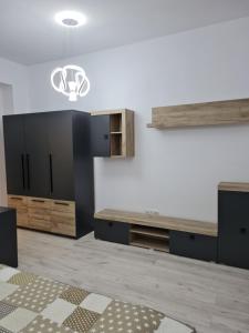 a kitchen with wooden cabinets and a chandelier at Studio Deluxe in Chiajna