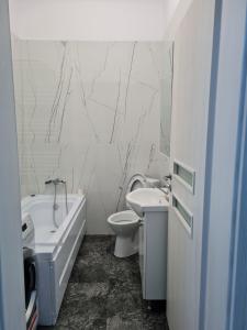 a bathroom with a toilet and a tub and a sink at Studio Deluxe in Chiajna