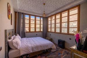 - une chambre avec un lit dans une pièce dotée de fenêtres dans l'établissement Riad Atlas Dreams Imlil, à Imlil