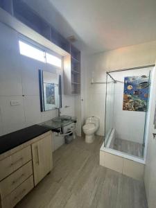 a bathroom with a toilet and a glass shower at Casa zumar in Coveñas