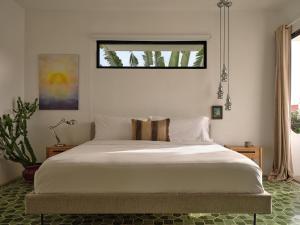 Schlafzimmer mit einem großen weißen Bett und einem Fenster in der Unterkunft CASA FRIDA by DW in San Juan