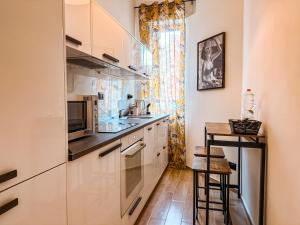 a kitchen with white cabinets and a counter top at Fortuna Milan - METRO, AC, DUOMO in 25 minutes in Sesto San Giovanni