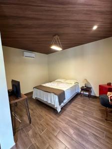 a bedroom with a bed and a wooden ceiling at Fazenda Penedo in Duas Barras